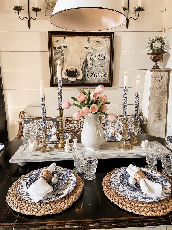 Spring Dinner table Setting with blue and white dishes and candles with ironstone pitcher with pink tulipes. 