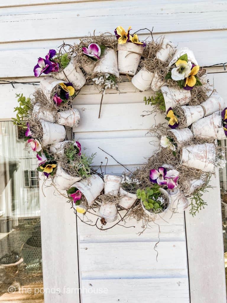  inexpensive this terra cotta pot wreath made with Dollar Tree pots and fake flowers.  Spring wreath for outdoors.