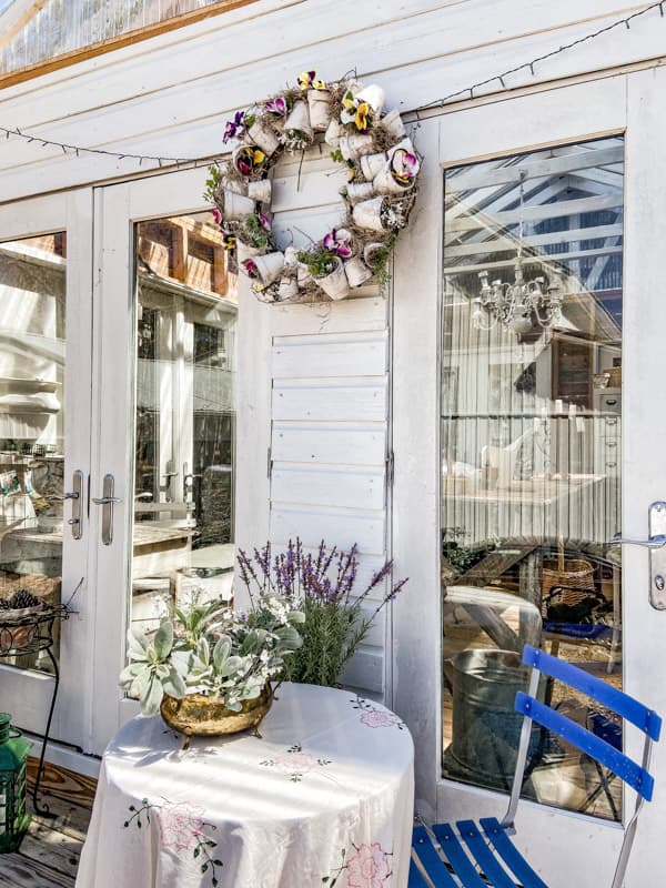 Terra Cotta Spring Wreath on DIY greenhouse