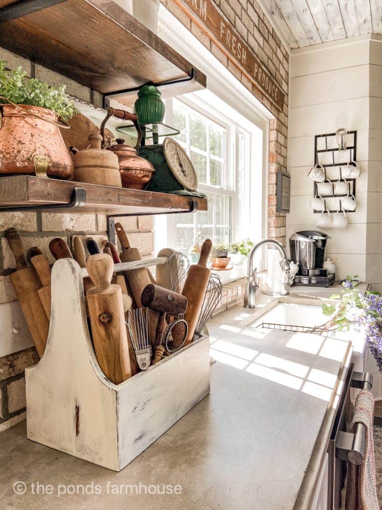 Antique scale & copper against a brick wall with apron front skin and shiplap wall in modern farmhouse kitchen