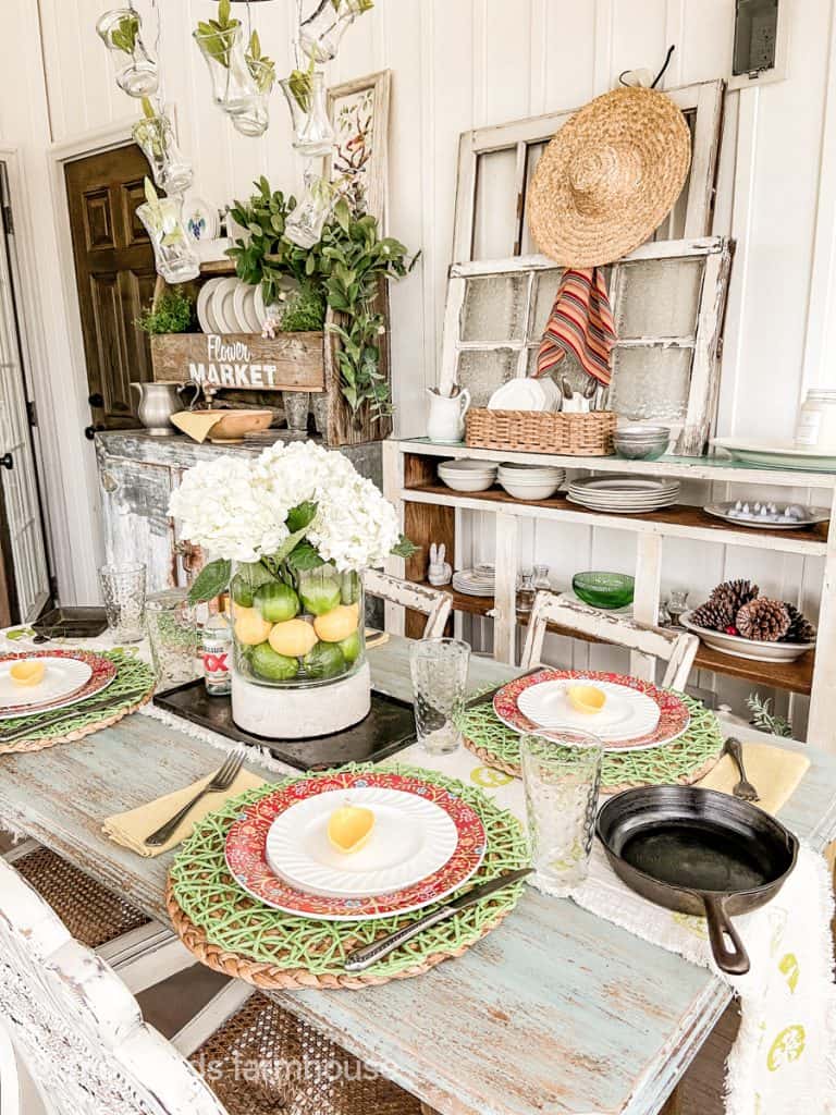 Table setting ideas for Cinco de mayo party featuring Dos Equis salt and pepper shakers, vase filled with lemons and limes, vintage silverware.