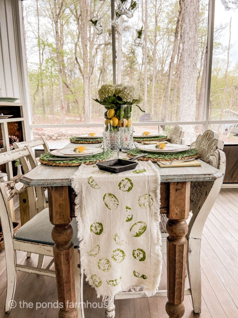 Cinco de mayo tablescape with hand crafted table runner. Table setting ideas using vase with lemons and limes topped with hydrangeas.