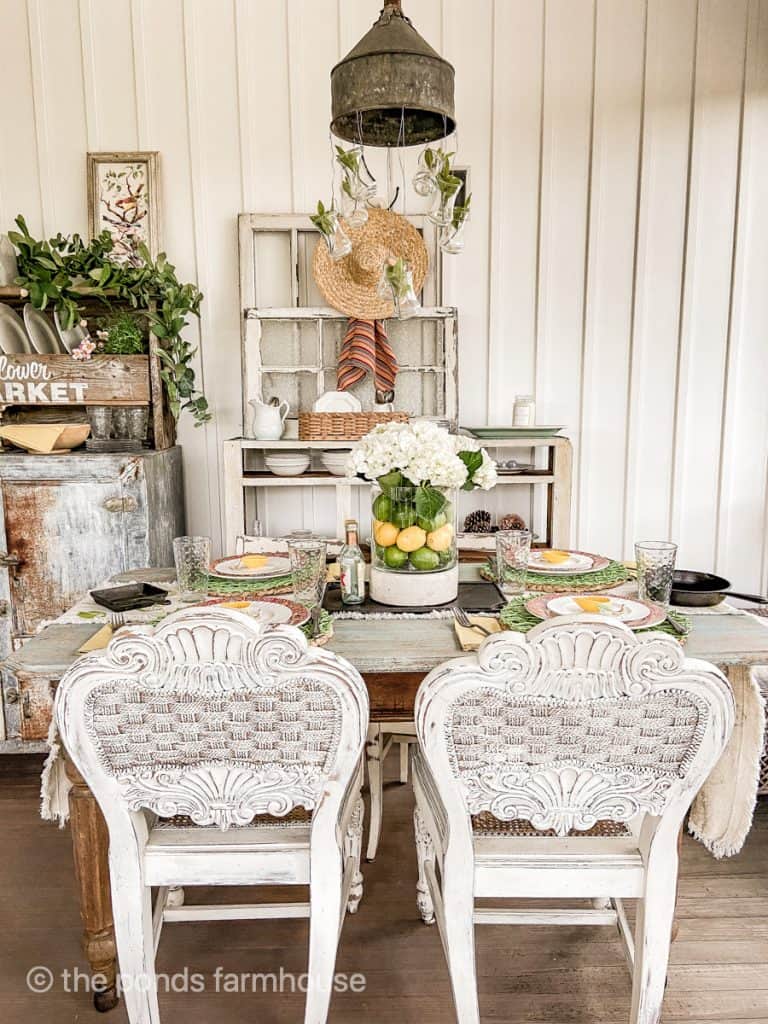 Table setting ideas for a Cinco de mayo party. Vase with lemon, limes, and hydrangeas, clear water glasses. 