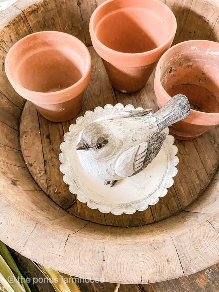 Use old clay pots, cake stand & birds to make floral arrangement for decorating coffee table. 