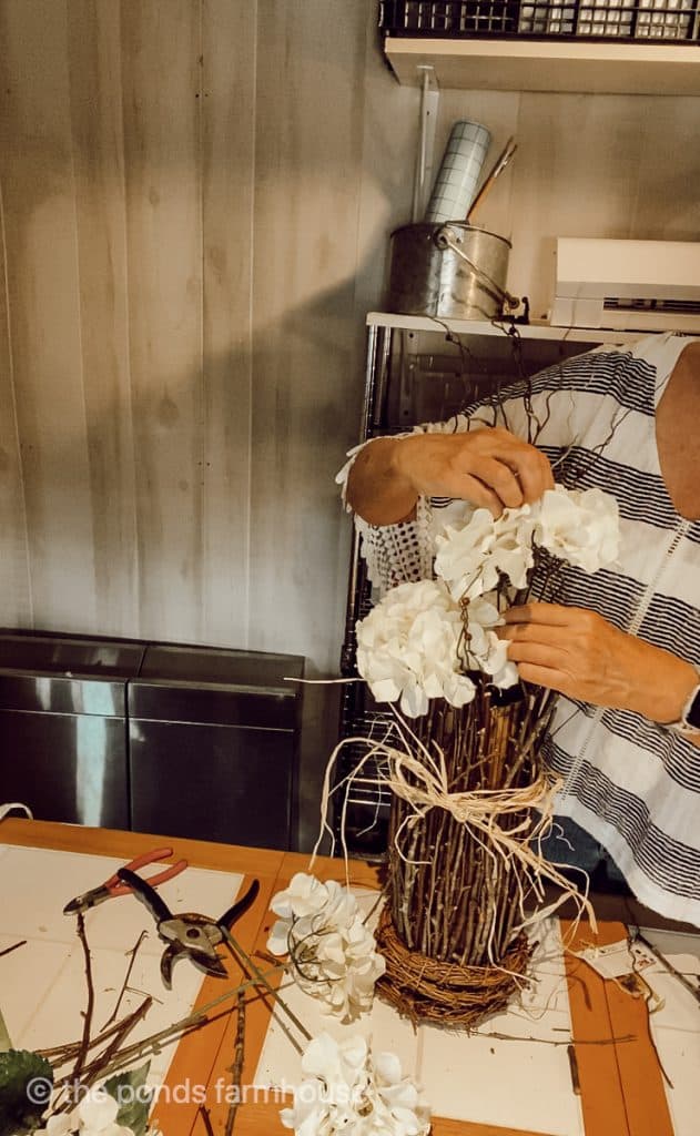 Add faux hydrangea flowers to the twig vase.