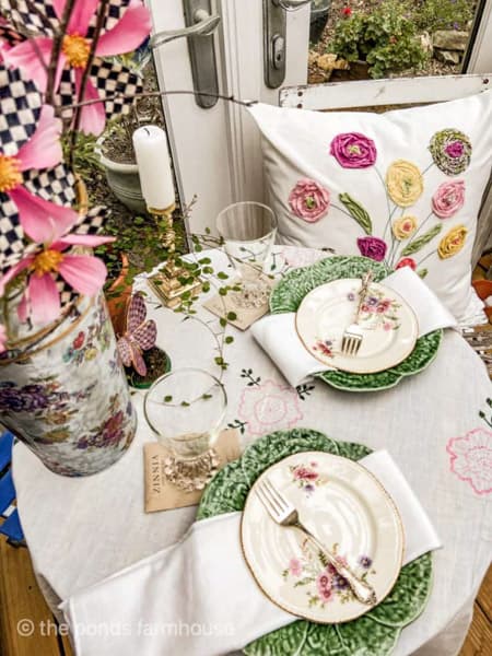 Vintage dishes with cabbage plates on bistro table for Mackenzie Childs Garden Party