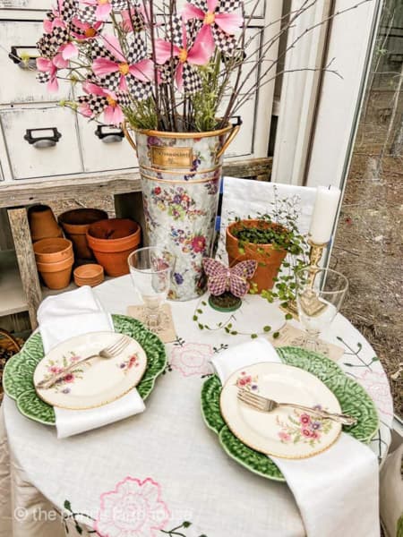 Vintage dishes with cabbage plates on bistro table for Mackenzie Childs Garden Party