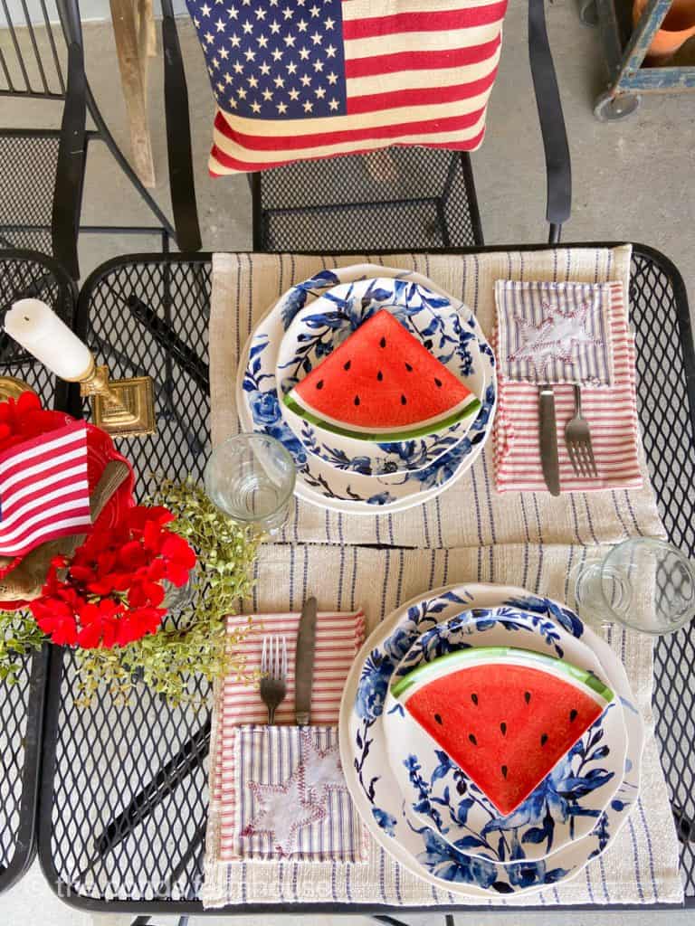 Easy Fourth of July Outdoor Table Setting with blue and white dishes, watermelon slice plates and DIY patriotic napkins.