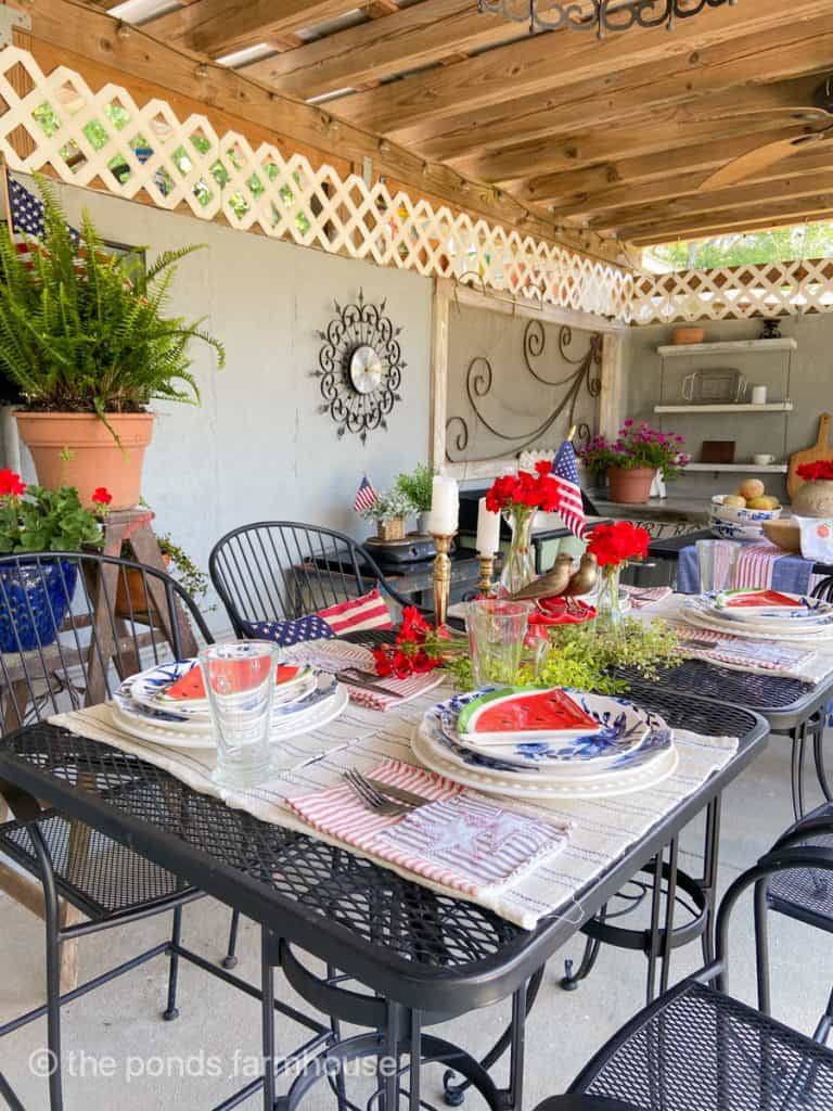 Easy Fourth of July Outdoor Table in the outdoor kitchen.  Keep the table simple & festive with lots of red, white & blue, DIY Napkins & Flags