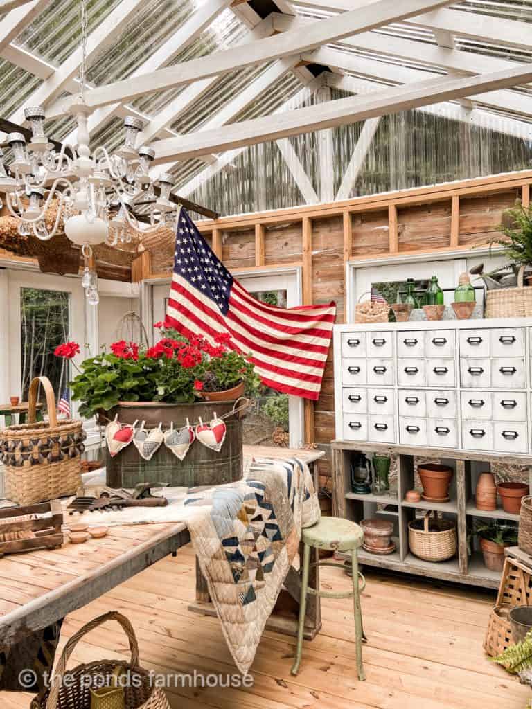 Greenhouse decorated for Fourth of July and Memorial Day with vintage flag and apothecary cabinet