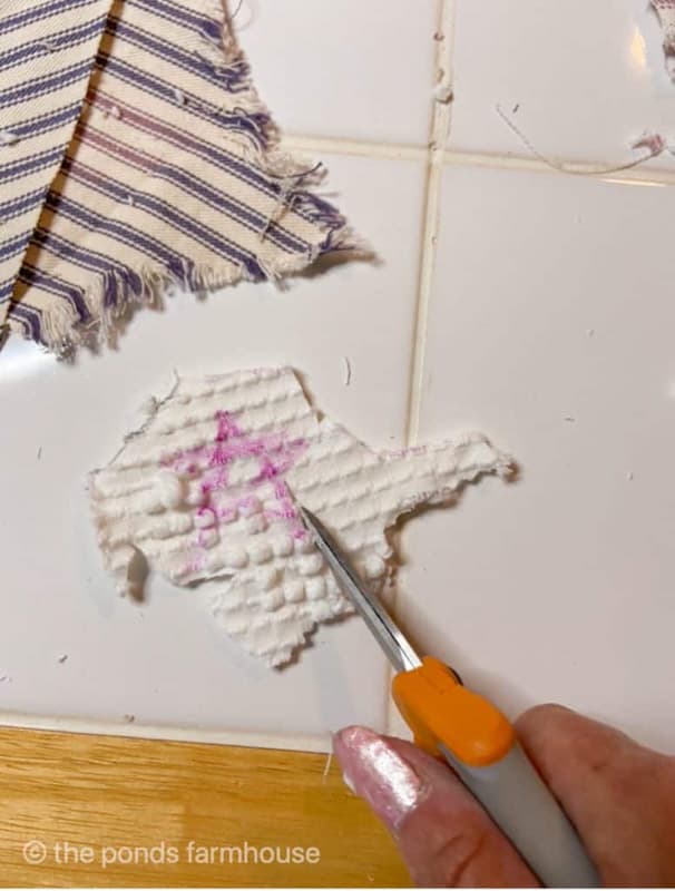 cut white stars from old bedspread for DIY pillow cover