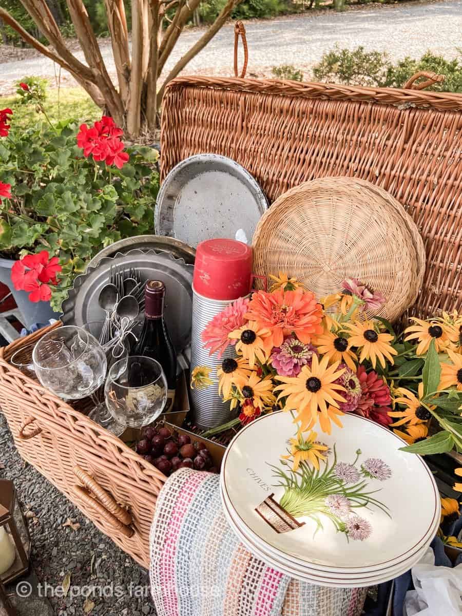 Alternative centerpiece ideas a picnic basket filled with picnic supplies and a bundle of fresh picked flowers.