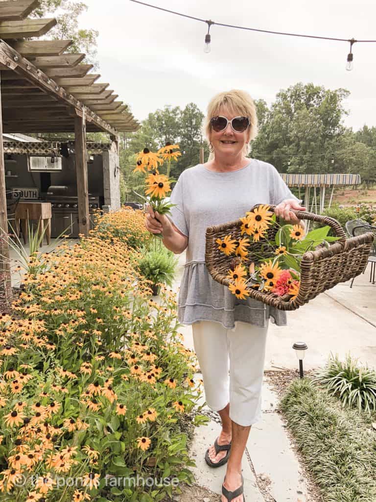 gathering basket filled with black eyed susans for a Summer PIcnic Table.  