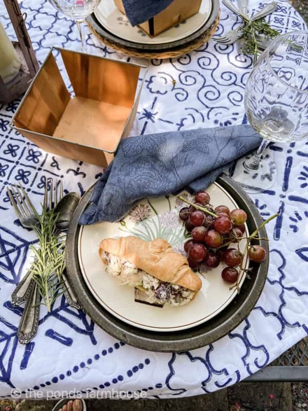 Picnic table setting with blue and white quilt