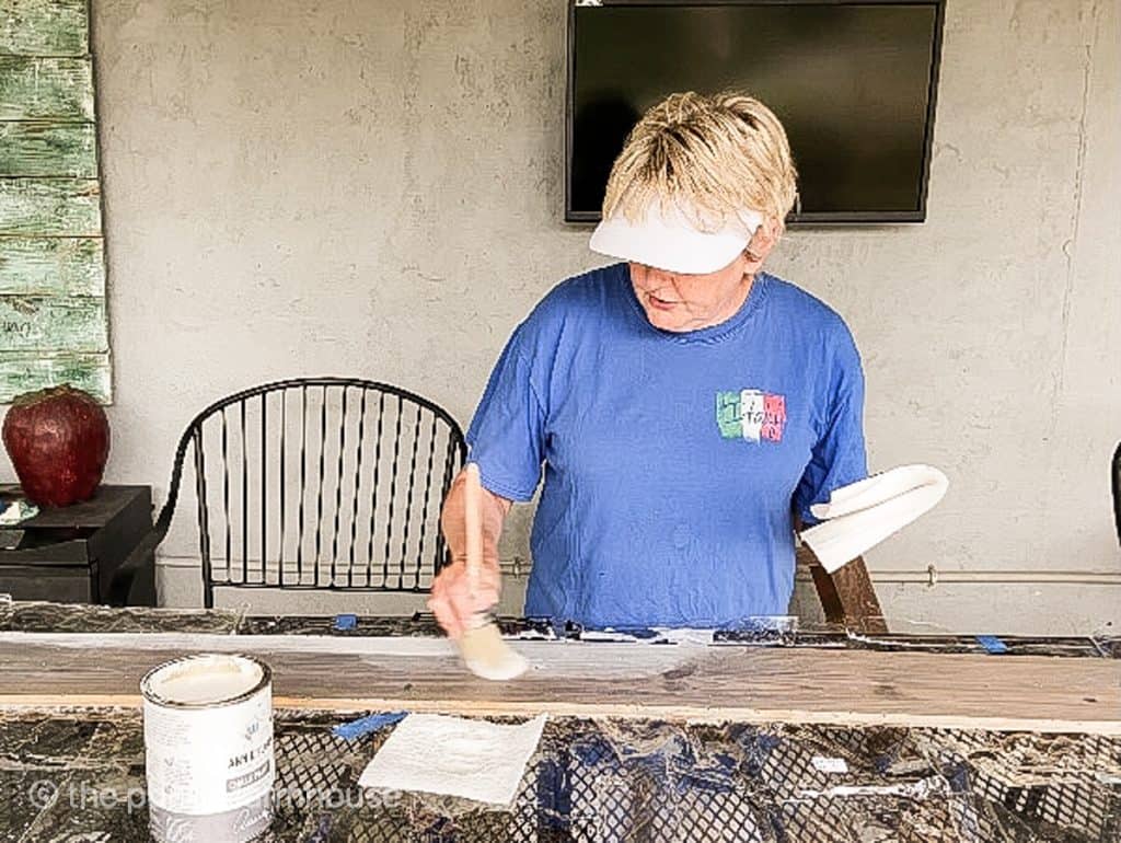 Begin adding a dry brush of white paint to white wash on wood.