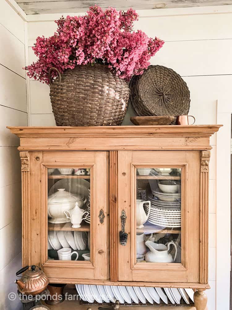 Vintage Thrift Store basket filled with pink flowers on antique pine hutch was a cheap home decor thrift store find.