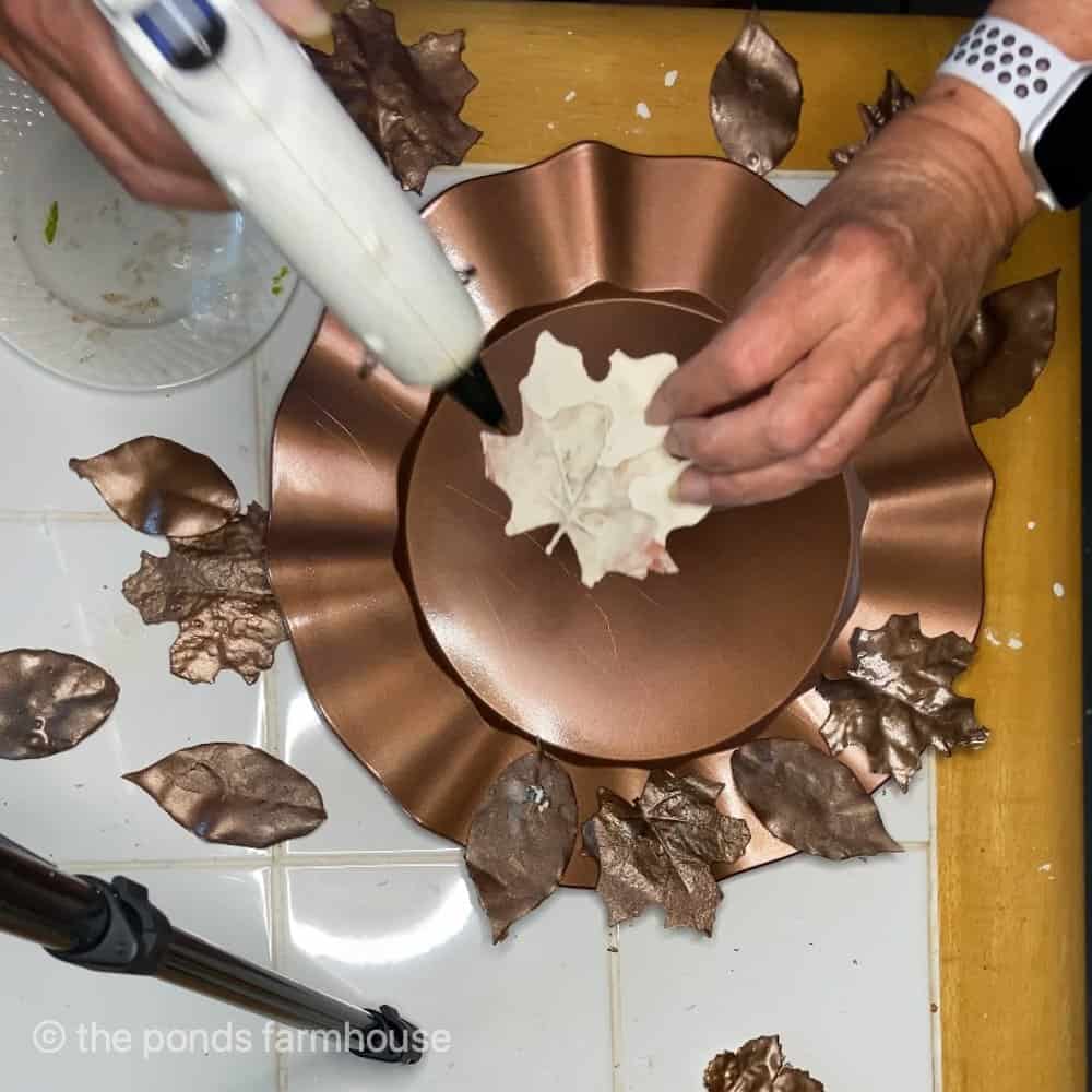 Hot glue to attach leaves to the thrift store plate chargers