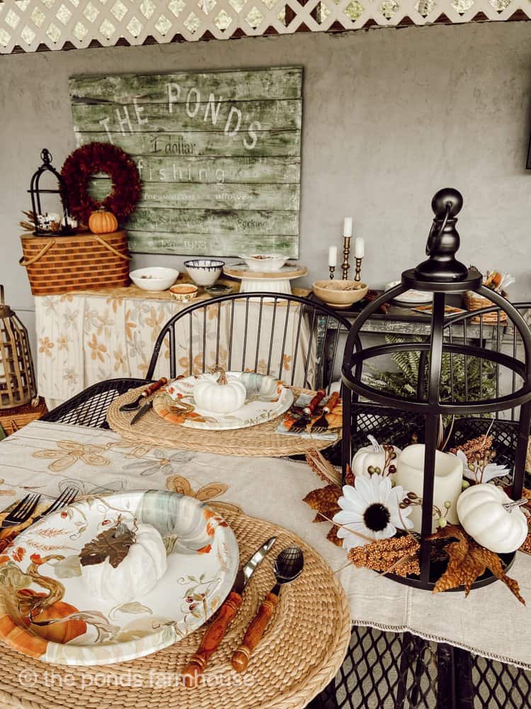 Farmhouse style outdoor decorating ideas for buffet table party.  Pumpkin plates and table lanterns. Reclaimed sigh, faux signs