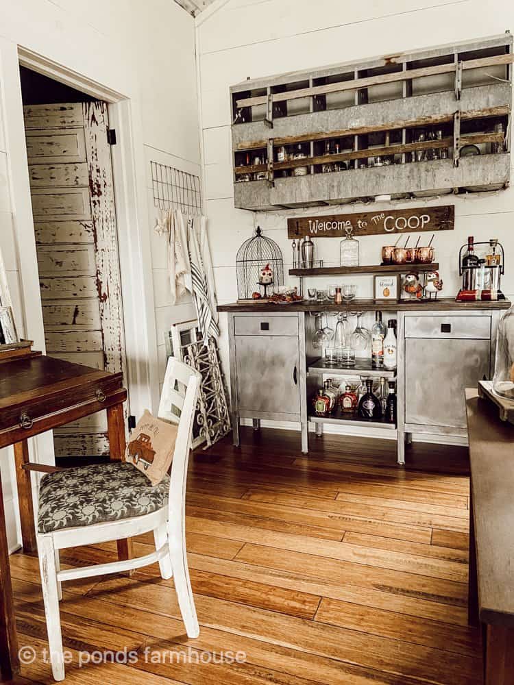 Farmhouse loft with dry bar made with chicken feeder and old hospital cabinet. vintage small desk and chair.