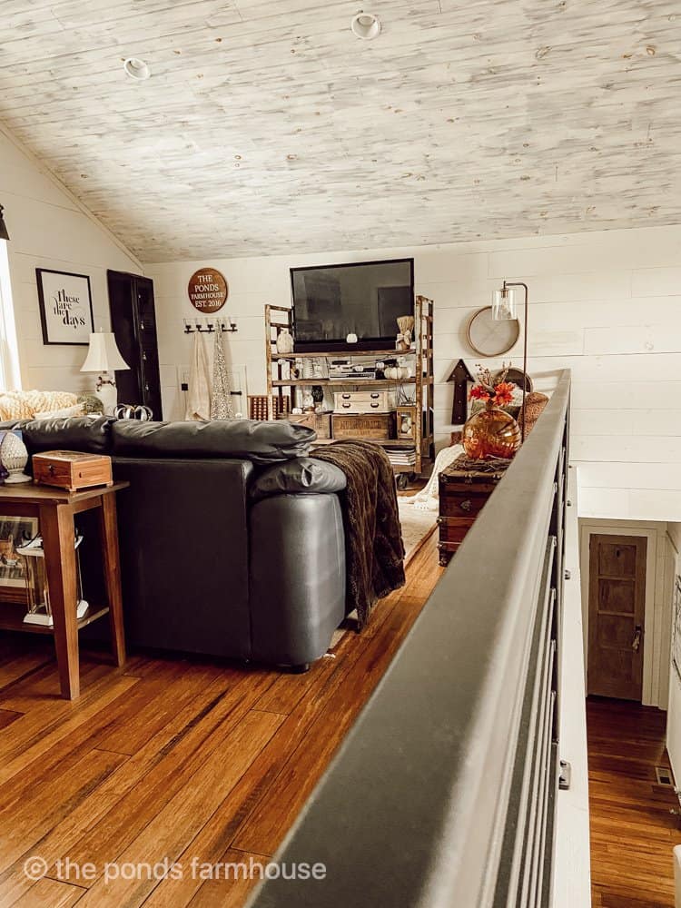 Sectional leather sofa surrounds the industrial cart repurposed as a TV stand.  