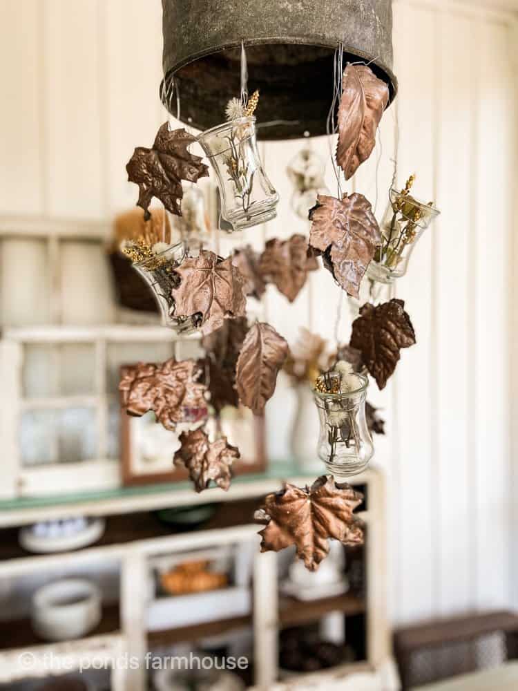DIY Fall Plaster Leaves are hanging from light fixture made with recycled faux leaves.  