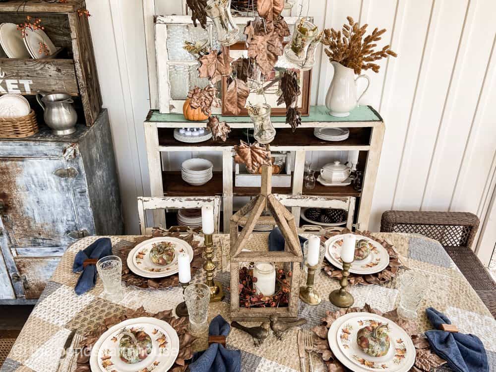 Fall Harvest Table Setting with DIY Copper Plaster Leaves on light fixture and plate chargers.  