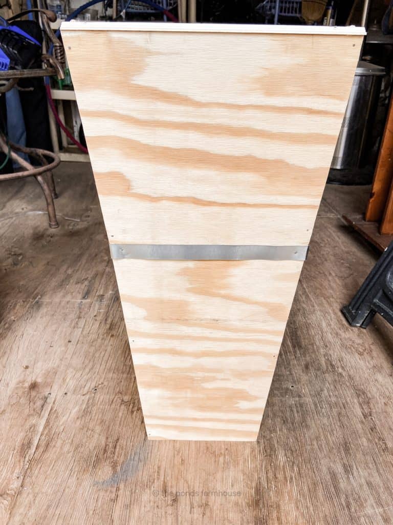Plywood planter with metal band around the middle.  