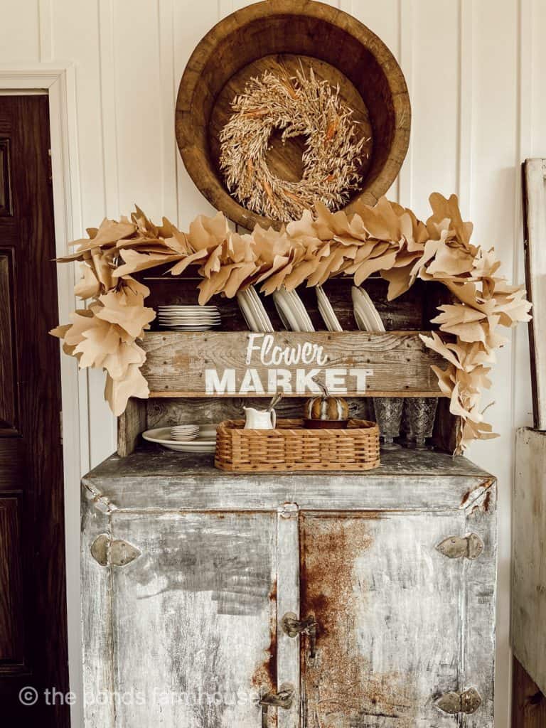 DIY Autumn leaves Garland displayed on a shelf. Easy Fall Craft Idea for cheap decoratiing.