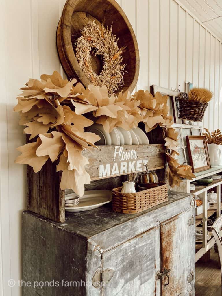 DIY Fall Leaf Garland setting on vintage ice box. vintage wooden container.