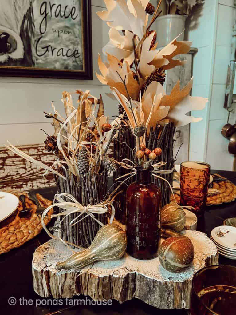 This DIY Fall Centerpiece idea is made up of twig containers and craft paper leaves, dried fruit and amber bottles.