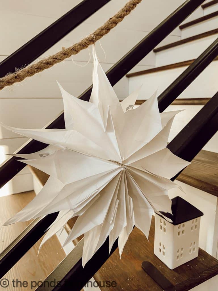 Creative Paper Bag Snowflakes made from White Paper Bags in a variety of shapes for the banister railing.