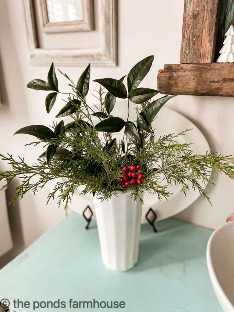 Christmas Greenery in a vintage milk glass vase with water will last longer.  Free Christmas Decorating Ideas with greenery.