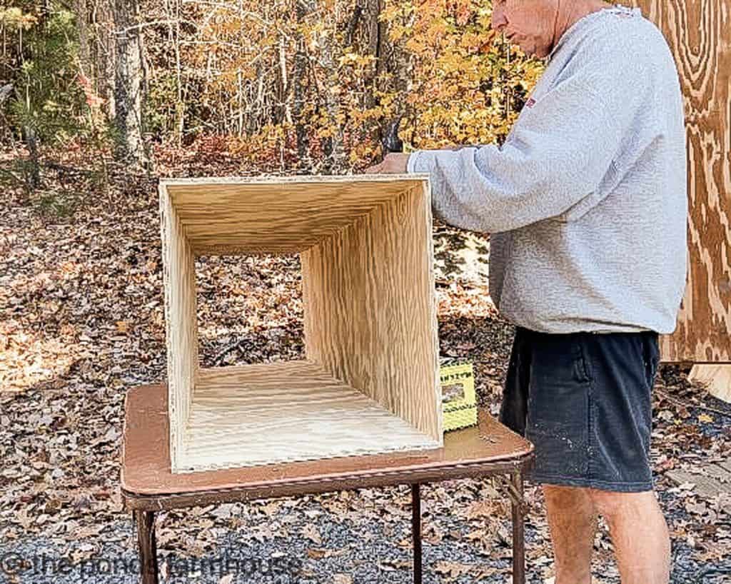 Plywood panels being put together with finishing nails.