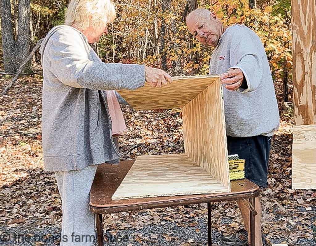 Plywood panels being put together with finishing nails.