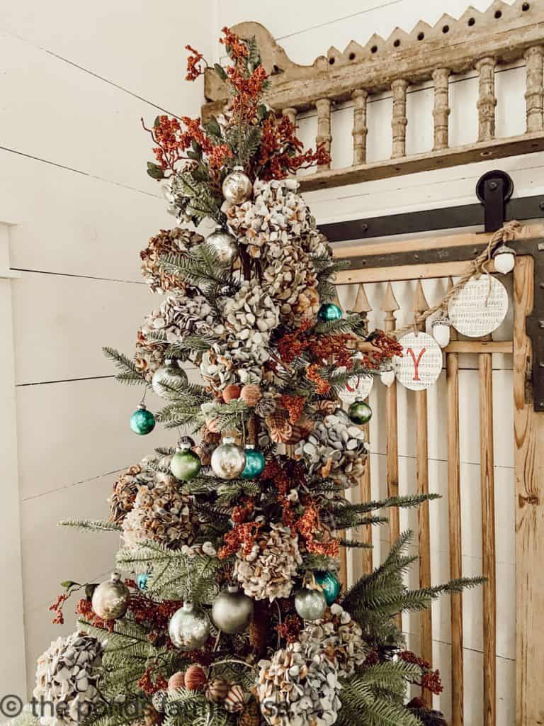 The tree is topped with stems and sustainable Christmas dried hydrangeas.  Vintage Barn Door and DIY Garland