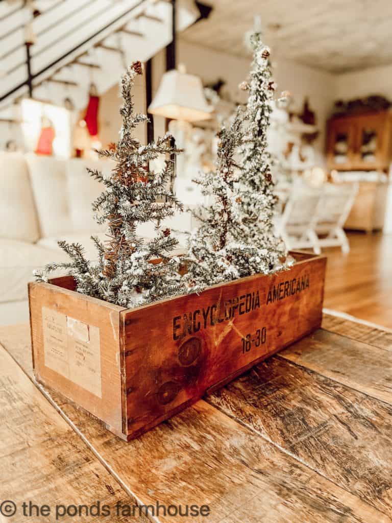 Vintage Wood Encyclopedia Box filled with flocked Christmas Trees on Repurposed Industrial Coffee Table.
