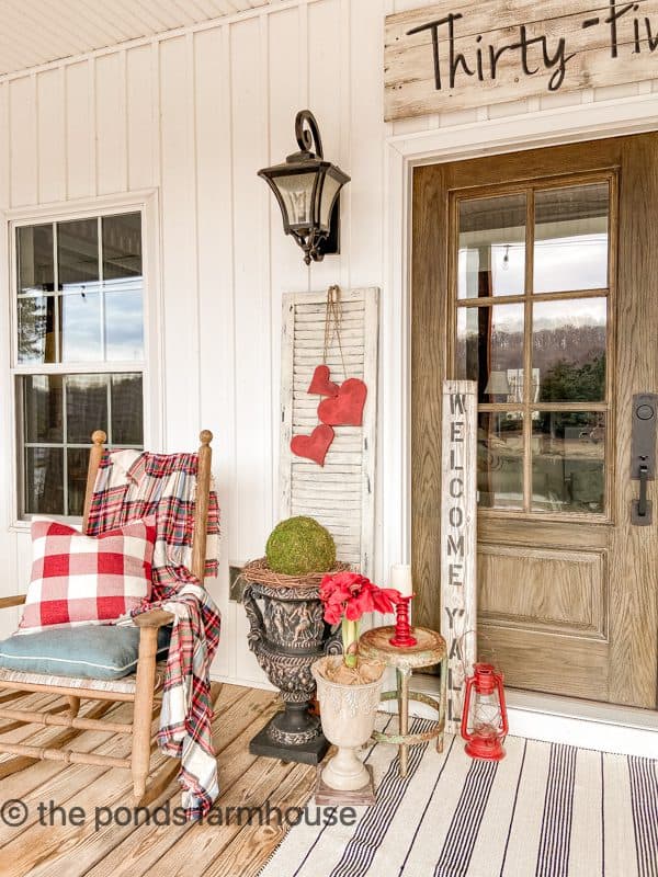 Cozy Winter Porch with plaid pillows and throw blanket surround the front door.  