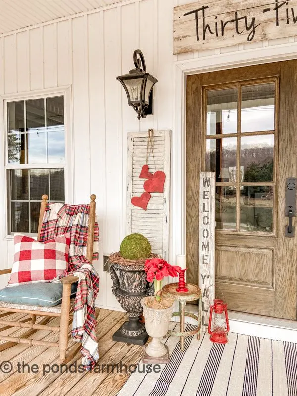 Cozy Winter Porch with plaid pillows and throw blanket surround the front door.  