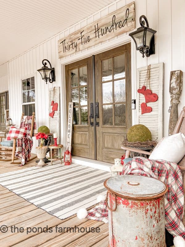 Front Porch with valentine's Day Decorations.  Wooden Heart Swags on white shutters