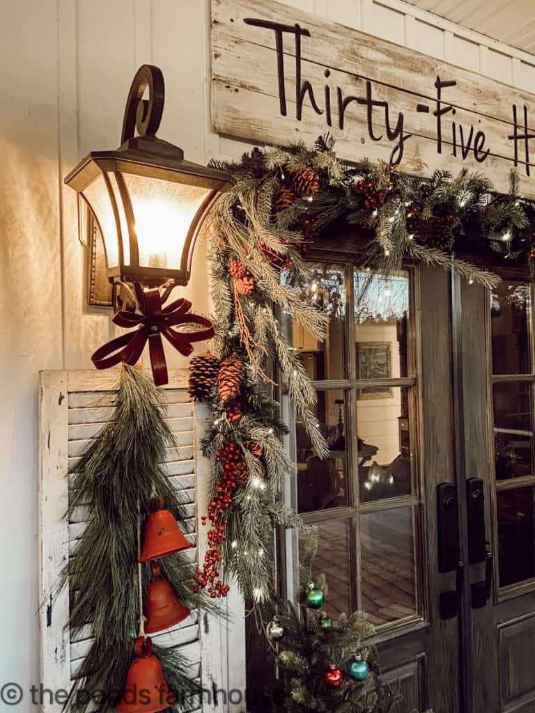 Christmas Decorations around the front doors.  Red bells and evergreen garland.  Vintage Shiny Brites.