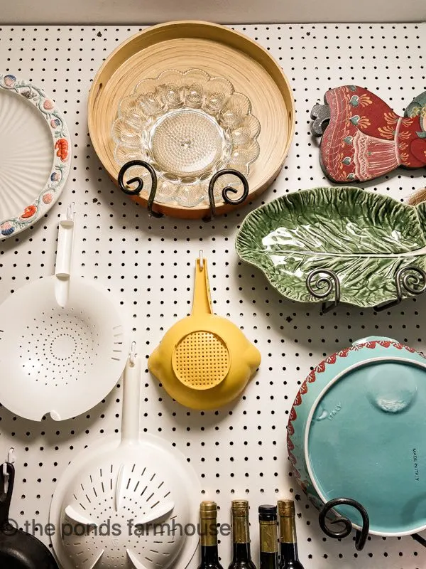 Wall of platters, tupperware and more on peg board wall.  