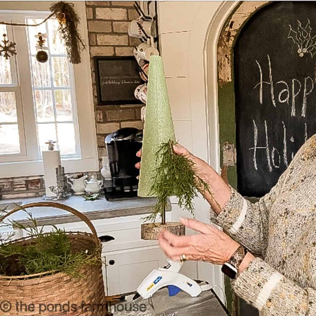 Use floral pick to attach cedar sprigs to the cone. 