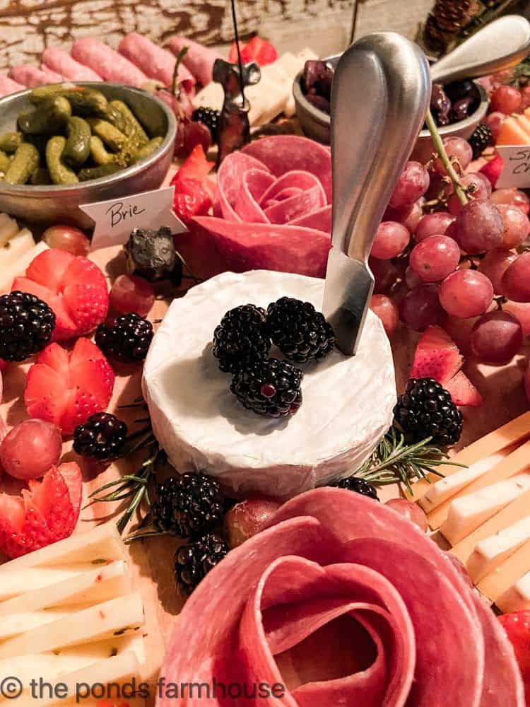 Charcuterie Board filled with salami rosettes, fruit and cheese.