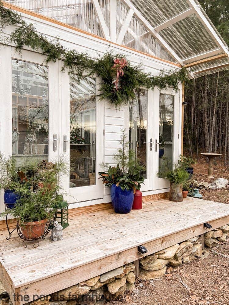 Fresh Cedar Garland and pine and cedar wreath on DIY Greenhouse. For free outdoor Christmas Decorating ideas
