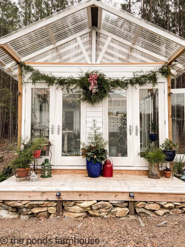 Greenhouse She Shed Decorated for Christmas with Fresh cedar garland and wreath.