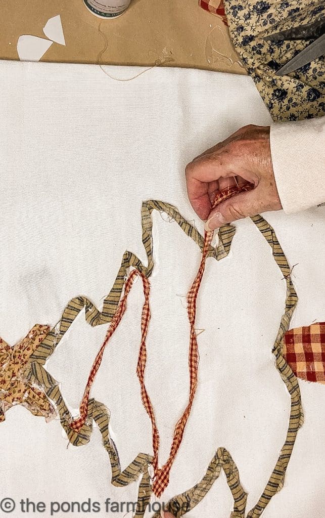 Attaching cloth to Christmas tree pillow.