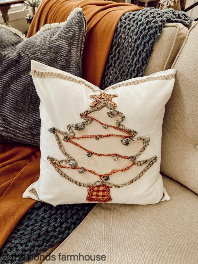 DIY Christmas tree pillow with ripped cloth, bells, and coffee stain.