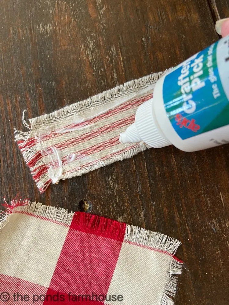 Use permanent fabric glue to attach pocket for no-sew Christmas DIY Cutlery Pocket Napkins.