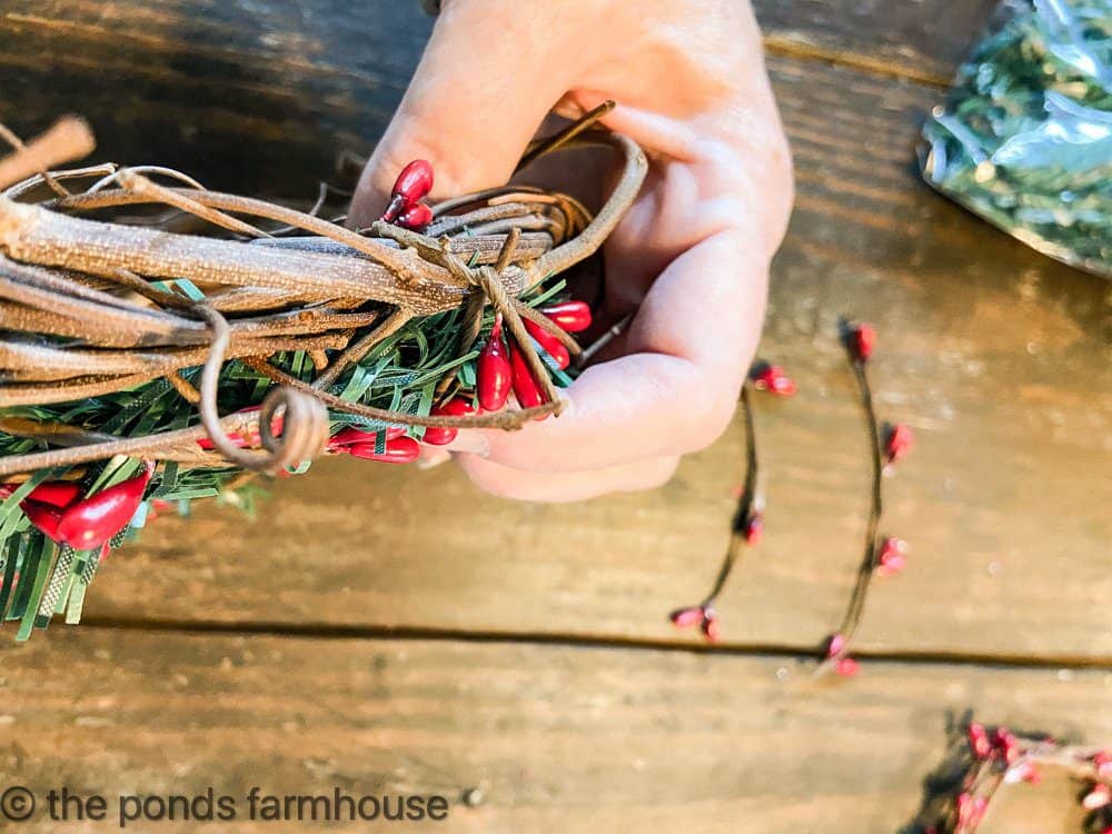 Use small pieces of the berry garland to attach to the grapevine wreath