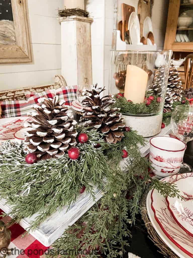 Foraged Pinecones and mini cedar wreath have faux flocking for a snowy look as the tables centerpiece
